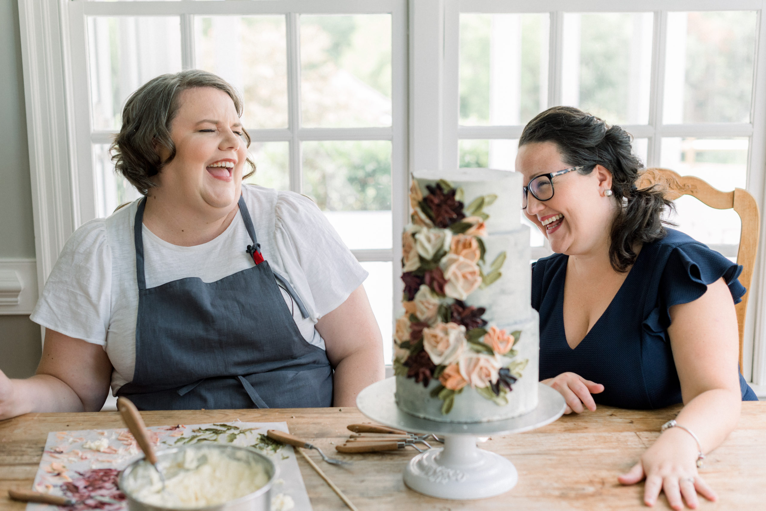 Miri of 10 Bloom Cakes + Jaclyn Hamilton of Timeless Love Weddings chatting while she decorates with butter cream 