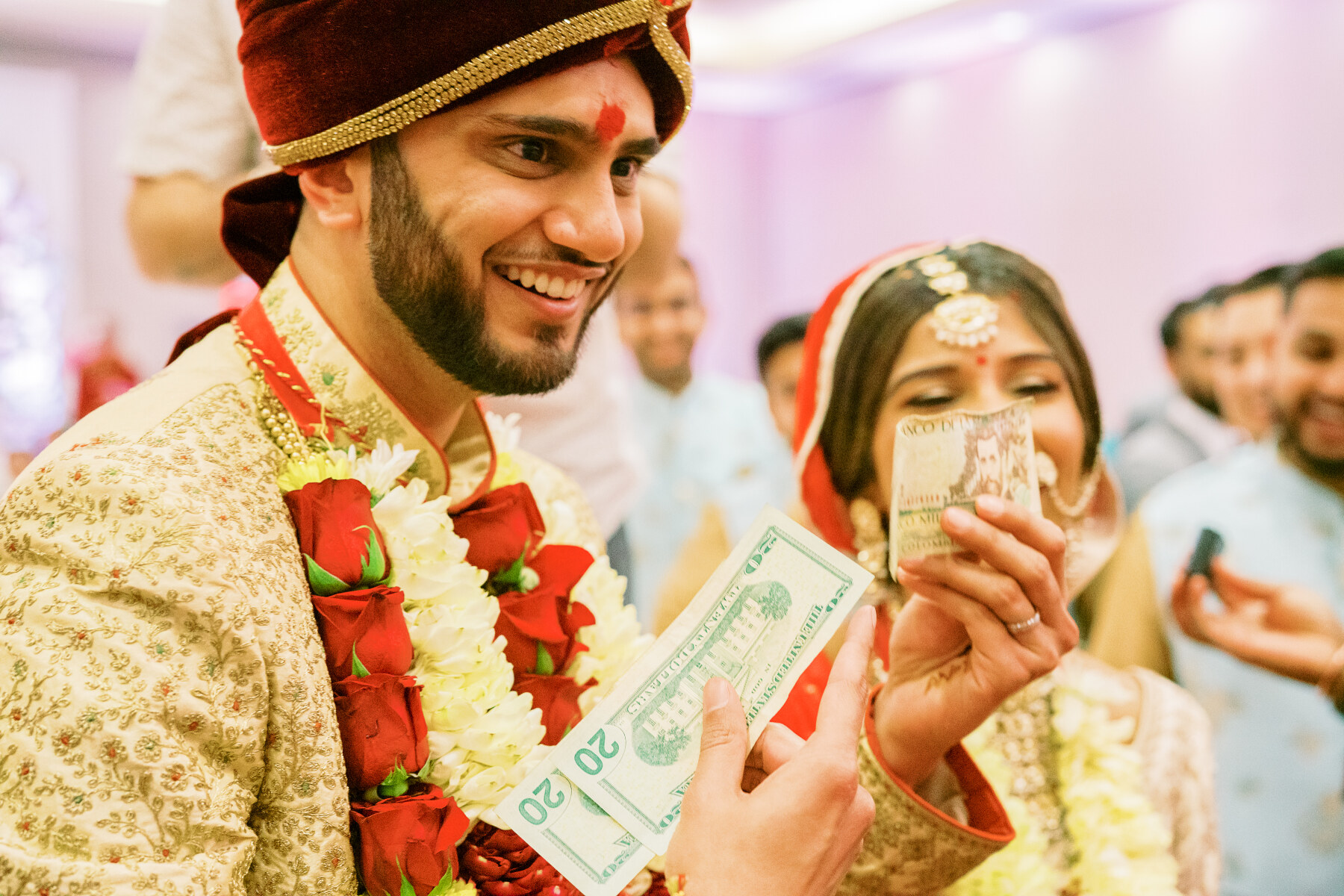 The groom paying for his stolen shoes during an Indian wedding captured by Jamie Vinson Photography