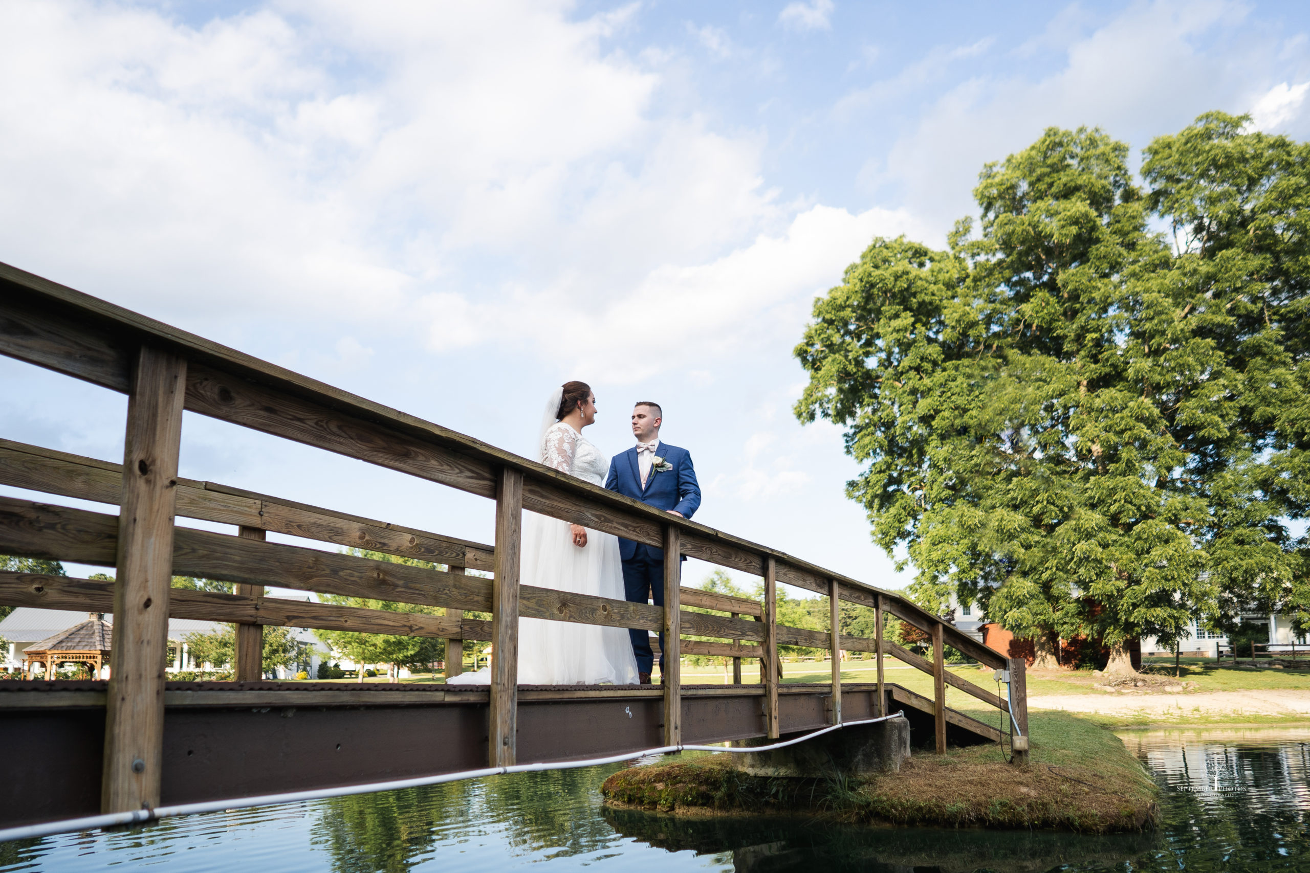 The beautiful couple getting photos on the bridge for their blush and gold wedding at Walnut Hill.
