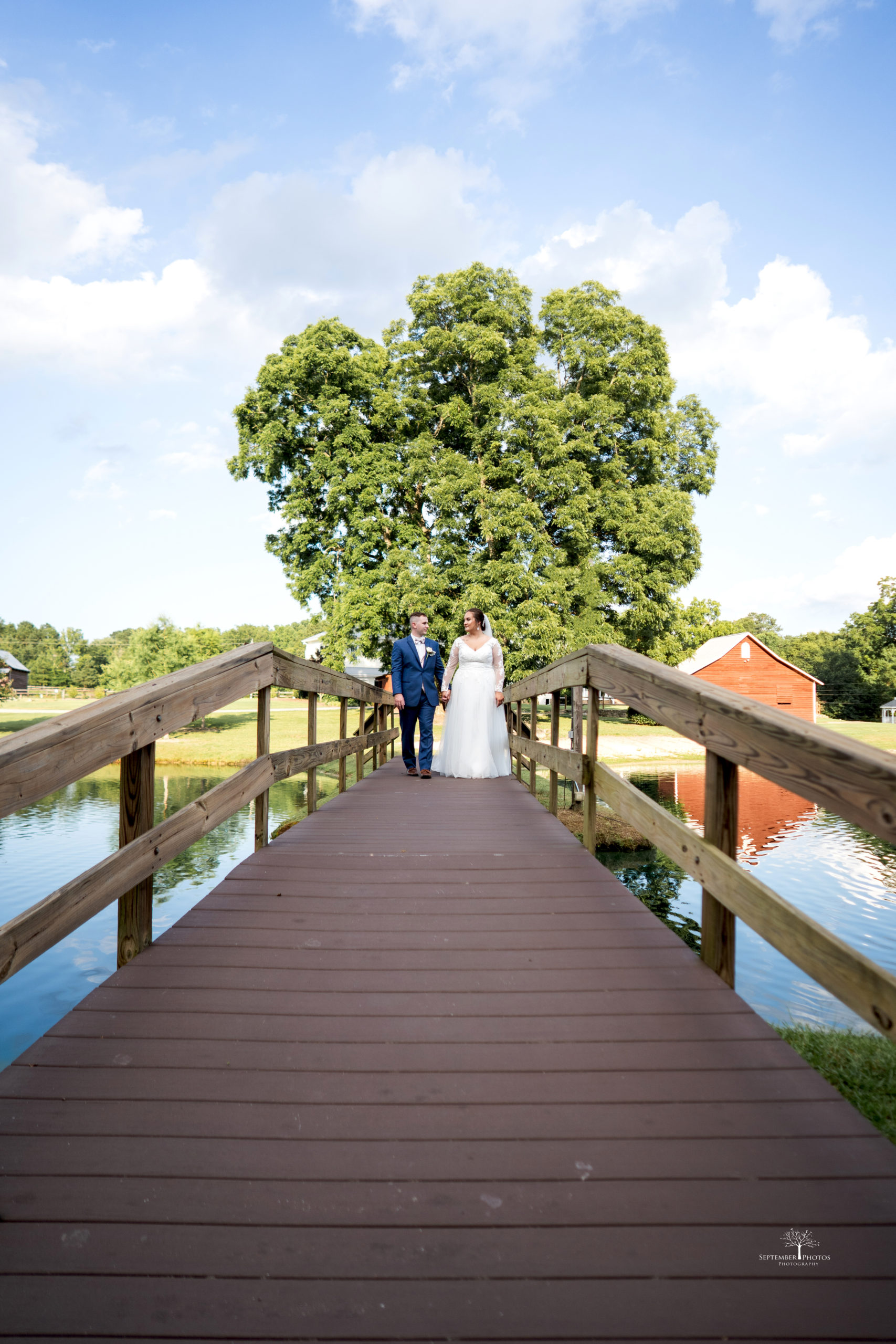 The beautiful couple getting photos on the bridge for their blush and gold wedding at Walnut Hill.